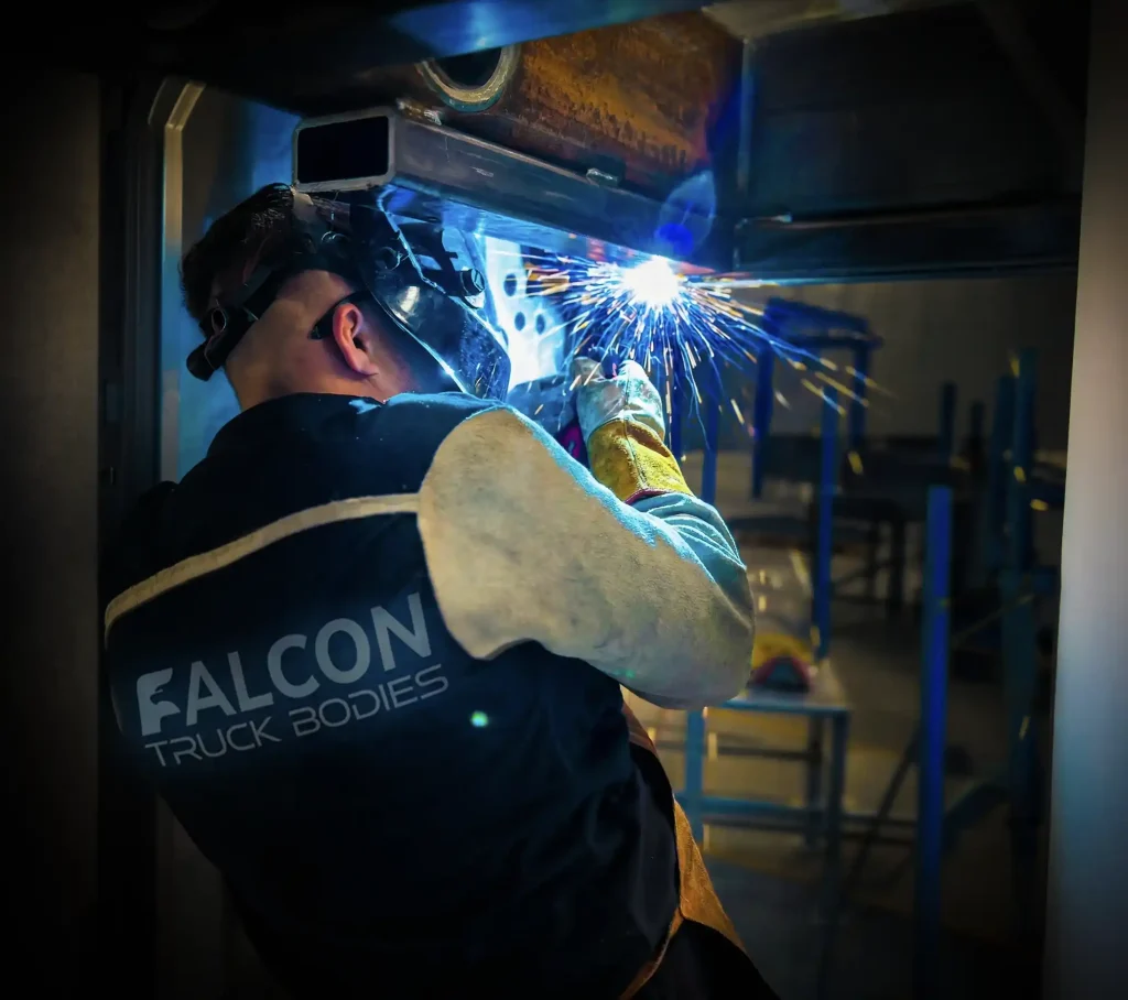 A welder fabricating a Falcon body